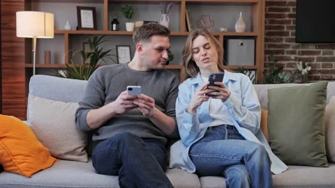 Couple sitting on couch together using their phones leisure activities. Video stock 172394857