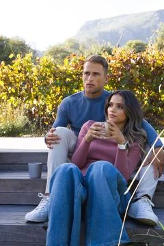 Couple sitting on deck steps in vineyard, woman holding ceramic mug, second mug, Stock Photos