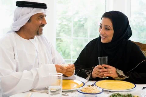 Couple sitting at dinner table smiling (high key) Stock Photos