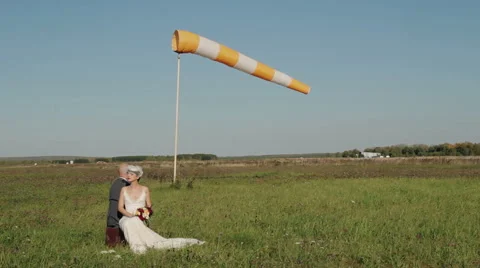 Couple sitting in a field near a developing flag Stock Footage 55799385
