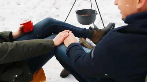 Couple sitting by the fire and holding hands. Concept winter love Stock-Footage 100015253