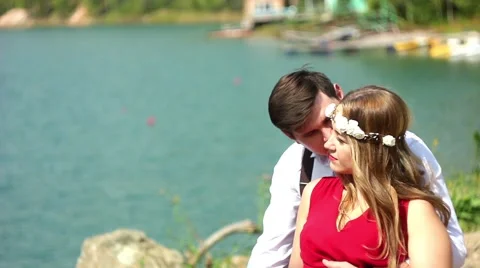 Couple sitting by lake Stock Footage 66527714