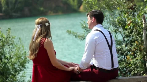 Couple sitting by lake Stock Footage 66527721