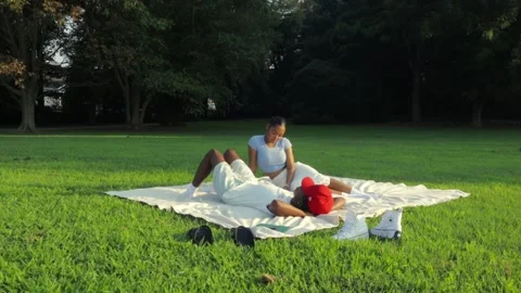 A couple sitting &amp; laying down in the park together in the day time Stock Footage 285563678
