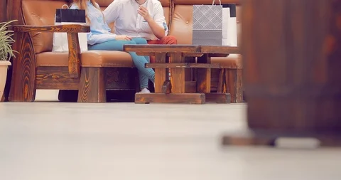 Couple is sitting in the mall on the couch and are discussing something Vídeo Stock 95963689
