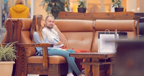 Couple sitting in the mall on the couch Stock Footage 95962590