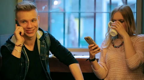 Couple sitting next to the window in the cafe and using smartphones Stock-Footage 49404120