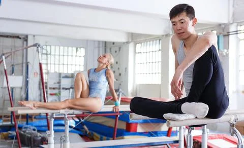 Couple sitting on parallel bars Stock-Fotos