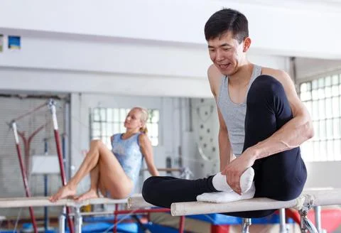 Couple sitting on parallel bars Stock Photos