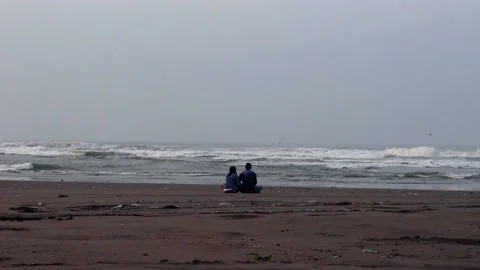 Couple sitting relaxing on beach Stock Footage 170754578