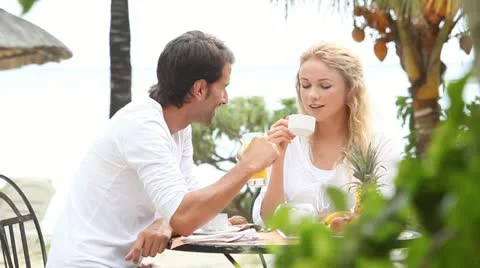 Couple sitting at resort table for breakfast Stock Footage 14827639