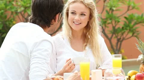 Couple sitting at resort table for breakfast Stock Footage 14827651