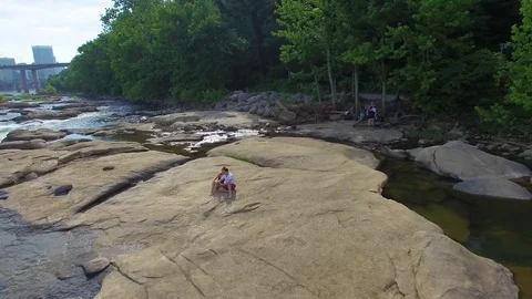 Couple Sitting on River Rocks Peaceful Nature Relationship 4K 库存影片 76944969