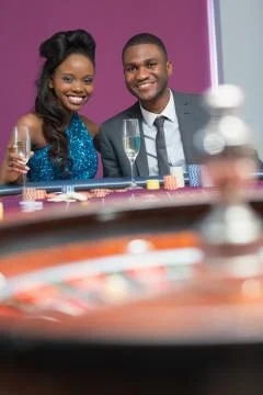 Couple sitting at roulette table Stock Photos