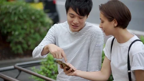 A couple sitting by the side of the road and having a conversation Stock Footage 147600977