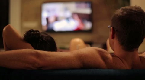 Couple sitting on sofa and watching television at night Video stock 40318081