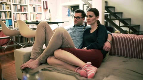 Couple sitting on the sofa and watching something on television Stockbeeldmateriaal 54098265
