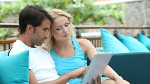 Couple sitting in sofa with electronic tablet Video stock 14827799