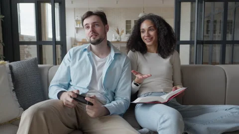 Couple Sitting On Sofa, Man Upset After Losing Game, Woman Comforts With Smile 스톡 동영상 306696005