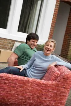 Couple Sitting On Sofa Outdoors Foto stock
