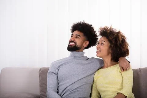 Couple Sitting On Sofa Stock-Fotos