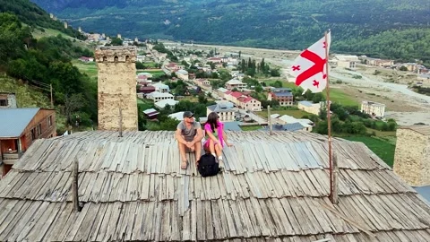 Couple sitting on Svan tower rooftop in Mestia, Svaneti, Georgia, Georgian .. Vídeos de archivo 317993069