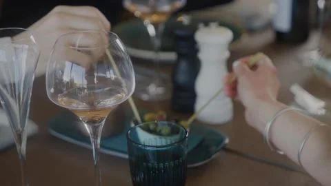 A couple is sitting at a table with wine glasses and a spoon Stock Footage 306576715