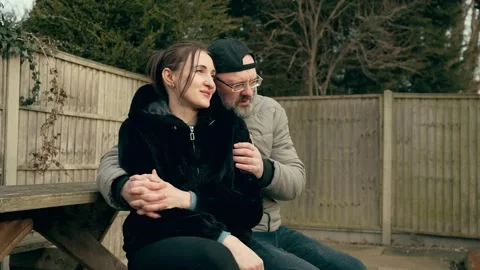 Couple sitting together on bench, holding hands and enjoying moment Stock Footage 306372000