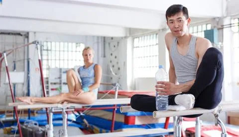 Couple sitting on top parallel bars Fotos Stock