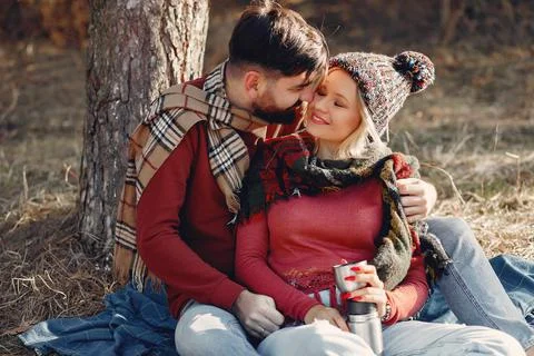 Couple sitting by the tree in a spring forest Stock Photos