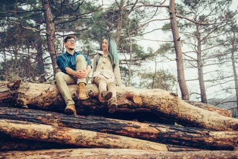 Couple sitting on tree trunk Stock Photos