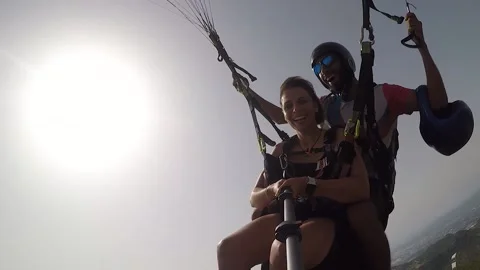 Couple of skydivers with helmets fly on coloured parachute Video stock 143358506