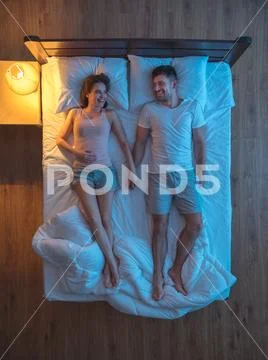 The couple sleeping and hold hands. evening night time. view from above Stock Photos