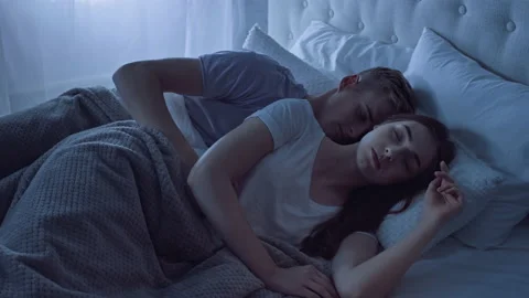 Couple Sleeping in Bed Cuddle at Night. Man Hugging Girl. Couple in Bed.  Shot on