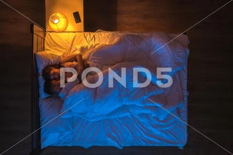 The couple sleeping on the bed. Evening night time. View from above Stock Photos