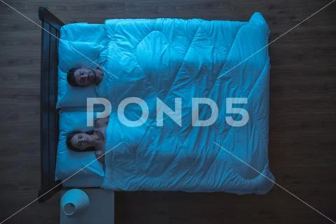 The couple sleeping on the bed. evening night time. view from above Stock Photos