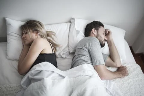 Couple sleeping in bed, ignoring each other avoiding sex, having conflict or  Stock Photos