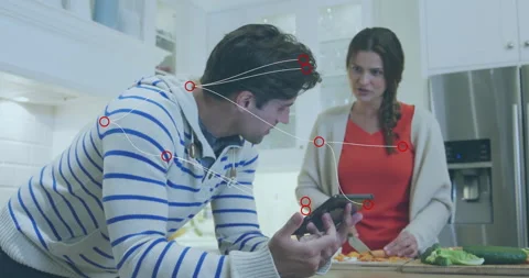 Couple slicing carrots and checking tablet in kitchen, showing animated health 스톡 동영상 310219332