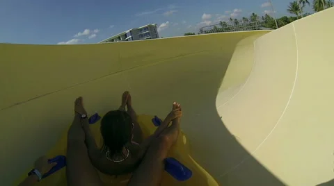 Couple sliding down a water slide at public swimming pool Stock Footage 64147659