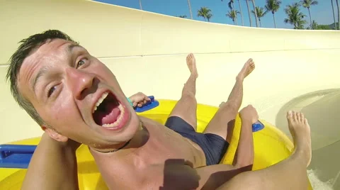 Couple sliding down a water slide at public swimming pool Stock Footage 64147807