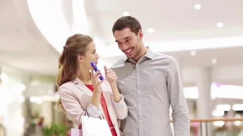 Couple with smartphone and shopping bags in mall Stock Footage