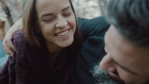 Couple smiling and talking to one another while lying on grass Stock Footage 275279357
