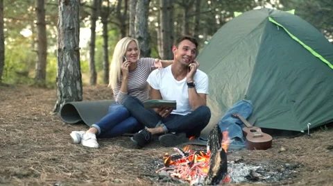 Couple smiling holding map speaking on phones in forest Slow motion Stock Footage 68115983