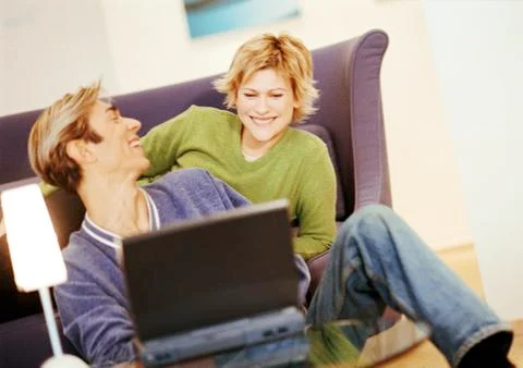 Couple smiling, using laptop Stock Photos