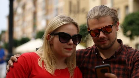 Couple smiling while checking something on smartphone Stock Footage 77476860