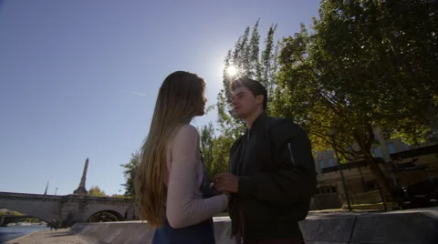 Couple sneak a kiss while taking a walk by the river. Stock Footage 63023917