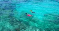 Couple Snorkeling In Clear Tropical Blue Water By Aerial Drone Stock Footage