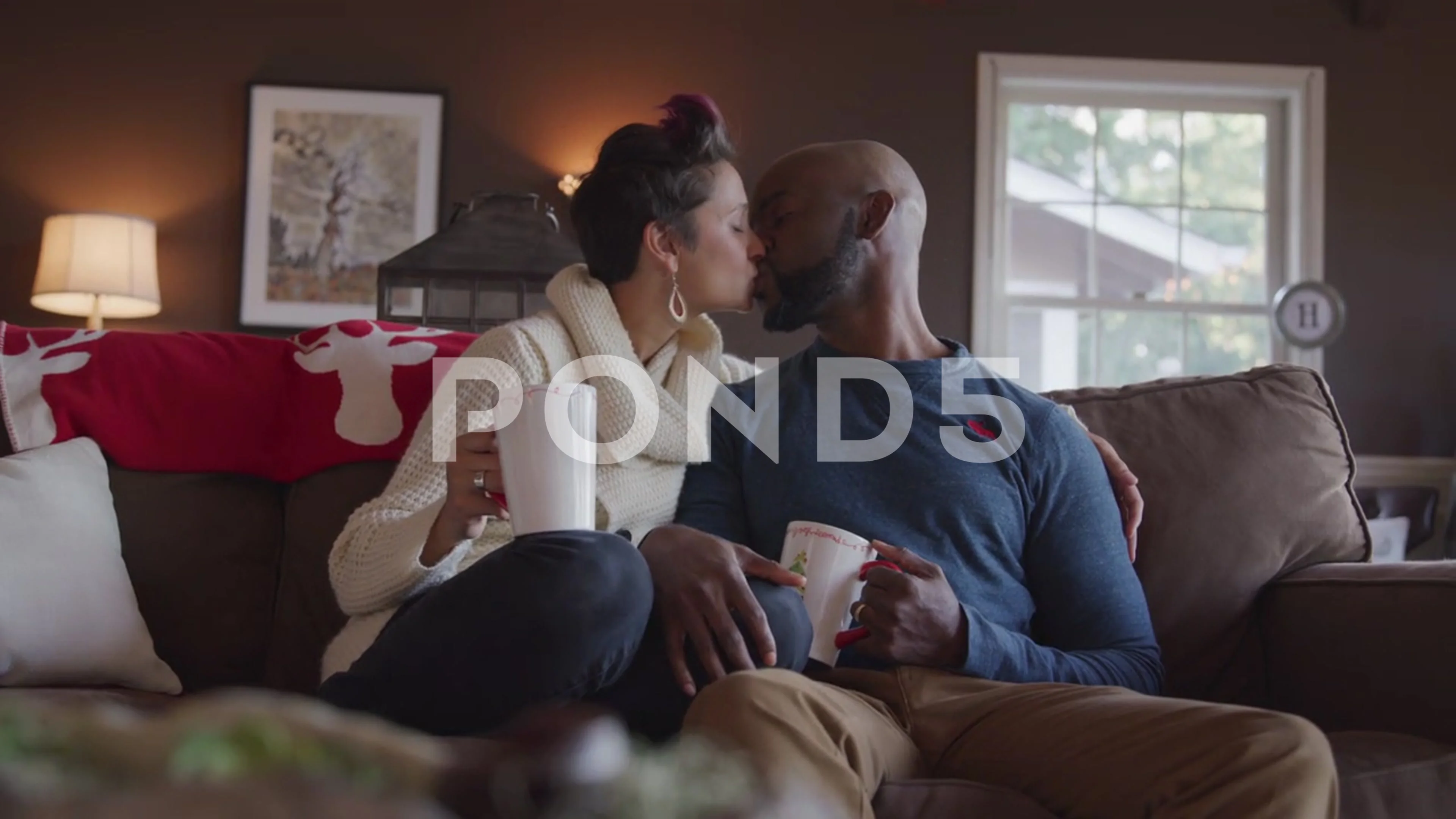 Couple Snuggle On Couch At Christmas TIme