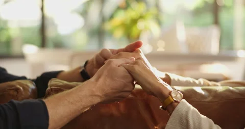 Couple, sofa and holding hands with empathy for trust, commitment or comfort in Stockbeeldmateriaal 310488608