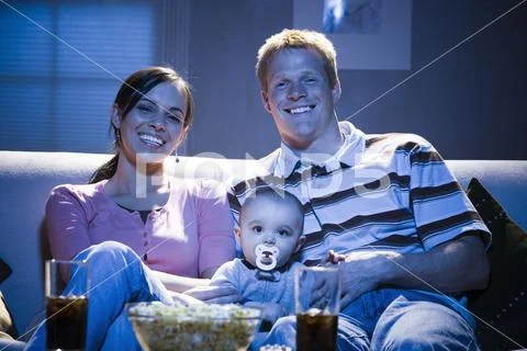 Couple On Sofa With Baby Smiling